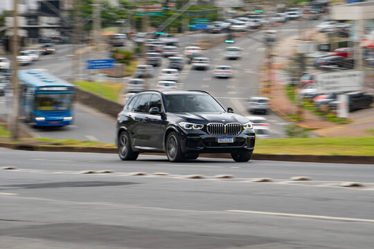 Black BMW X5 SUV front three quarter panning shot, German luxury vehicle driving in city