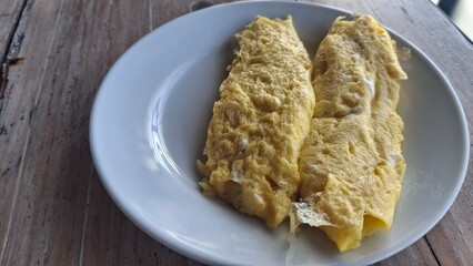 Close-up of a fluffy omelet on a white plate, set in a refined hotel breakfast environment, ideal for culinary, lifestyle, or food stock photography.