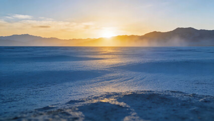 Obraz premium Vast desert landscape at sunrise with mountains and dust clouds in the distance