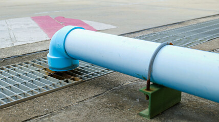 Large PVC pipe connected from the building roof to channel rainwater into the drainage system,