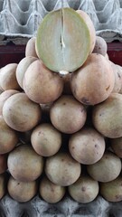 Close-Up of Fresh Sapodilla Fruit with One Cut Open in Market Display Indonesia