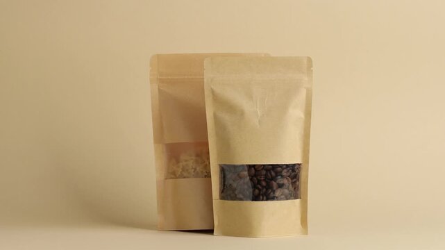 Woman putting stand-up pouches with different products on beige background