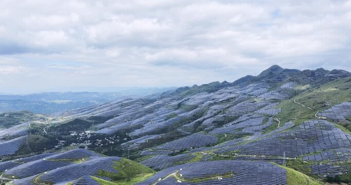 aerial video of a massive solar farm covering karst rocky desertification hills, showcasing large-scale clean energy and ecological transformation.
