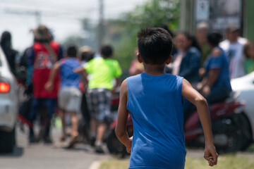 Photograph of a child in the foreground running towards the scene of an accident in Latin America with a blurred background