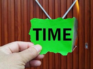 Close up picture holding burning green paper printed with the word time time management concept time not used will burn in vain