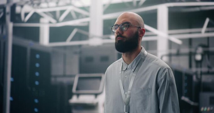 IT Professional Inspecting Rows of Active Server Racks. Male Engineer Walks Large Data Center, Conducting Physical Inspection of Glowing Server Racks. Security Protocol, Infrastructure Surveillance.