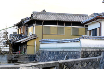 広い敷地に建つ立派な日本家屋と火の見櫓・石垣と塀に囲まれた伝統的な農家の風景・田舎の夕暮れ時の静寂と日本の原風景 © taka