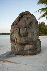 stone statue on a beach in bora bora at sunset