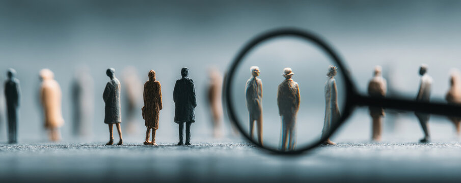 Miniature people under magnifying glass.