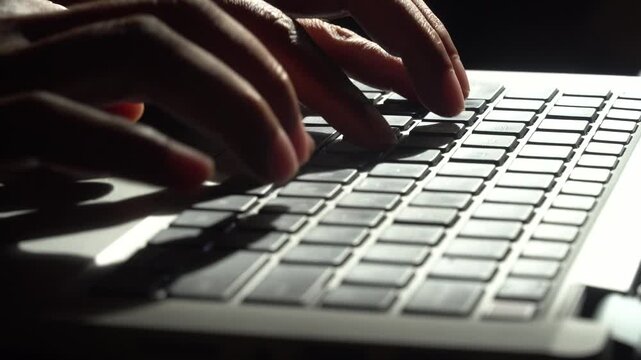 Fingers typing on a laptop keyboard. Focus selected.