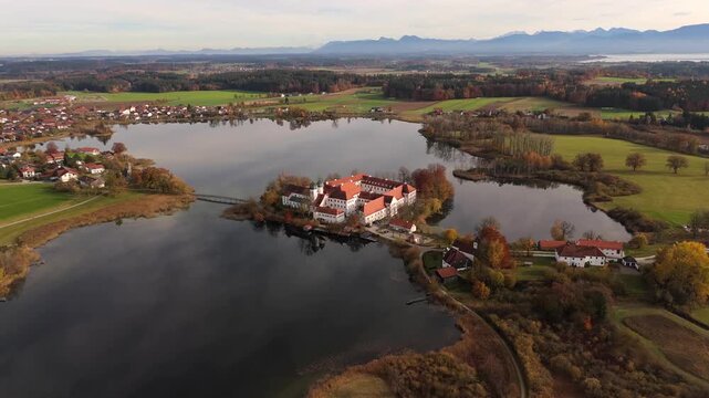 Historic monastery complex Kloster Seeon with St. Nikolaus Chapel, seen from above in golden autumn colors, Traunstein district, Bavaria, Germany. Luftaufnahme Kloster Seeon in Seeon-Seebruck. 