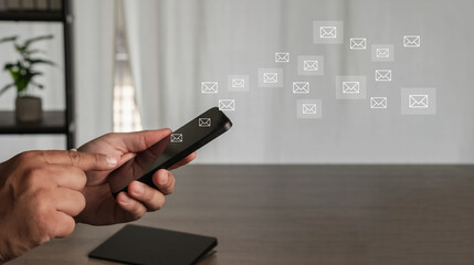 sending email concept smartphone in hand on office desk, concept of mail communication between laptop and computer in cyberspace, modern technology for business messaging.