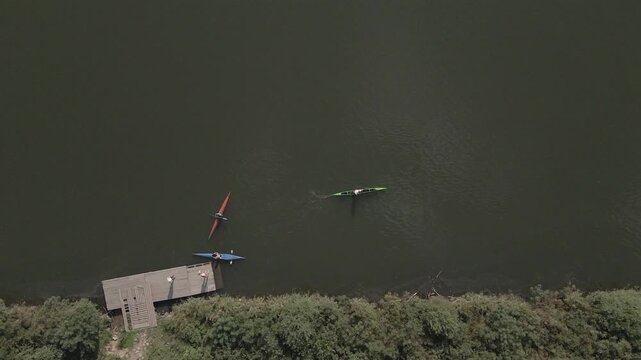 View from above. A rower trains on a kayak on the lake.
