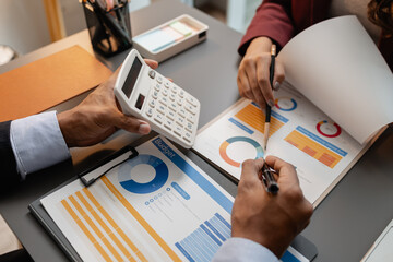 A business meeting scene where professionals review financial charts and exchange insights, highlighting strategic planning and collaborative decision making in a modern office environment.