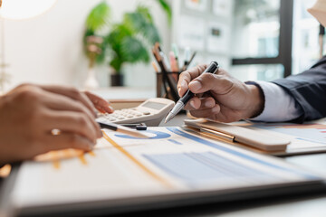 A business meeting scene where professionals review financial charts and exchange insights, highlighting strategic planning and collaborative decision making in a modern office environment.