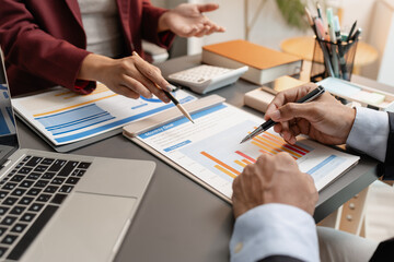 A business meeting scene where professionals review financial charts and exchange insights, highlighting strategic planning and collaborative decision making in a modern office environment.