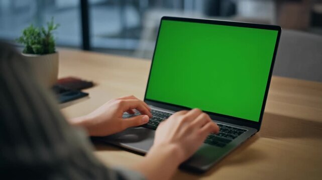 Person Typing on Laptop with Green Screen