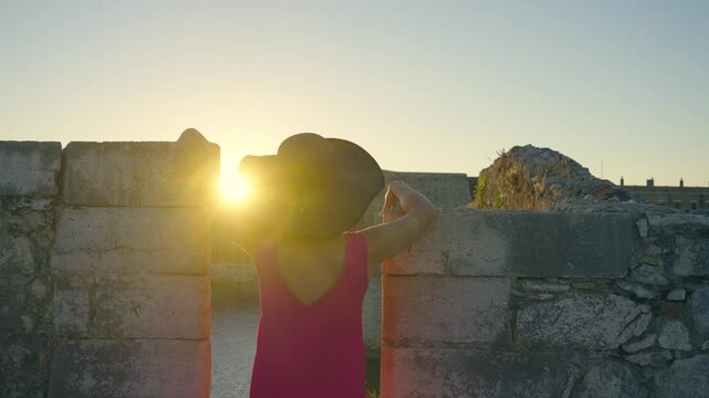 Tourist travel woman in Corfu, Greece. Happy elegant fashion model enjoying vacation in old town visiting famoust landmarks in Crofu island, Greece, slow motion