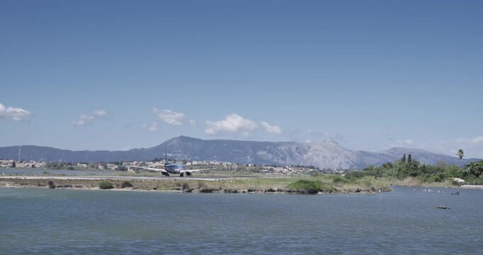 Passenger plane speeding on runaway to take off on airport in Kerkira city on Corfu island in Greece, slow motion