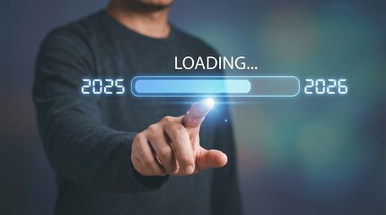 A man's finger points at a loading bar transitioning from 2025 to 2026 symbolizing progress and the arrival of the new year year change future technology digital concept business pointing