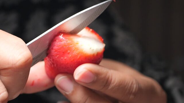 Cutting a fresh strawberry in the kitchen