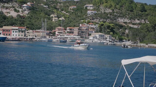Tourist boat sailing on the port of Gaios, the capital of the Greek island of Paxos, nearby Corfu island, Greece, slow motion