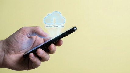 High level planning cloud strategy smartphone screen with hand holding mobile device and digital download icon glowing softly yellow background