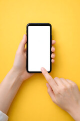 Hand Tapping Blank Smartphone Screen Mockup on Vibrant Yellow Background. Top View Mobile Phone Template for App UI/UX Design, Digital Marketing, and E-commerce Concepts.