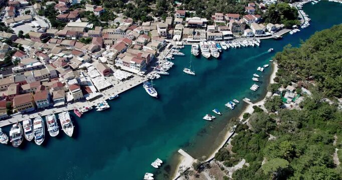 Picturesque village port in Paxos with turquoise sea, Ionian islands of Greece, aerial drone shot