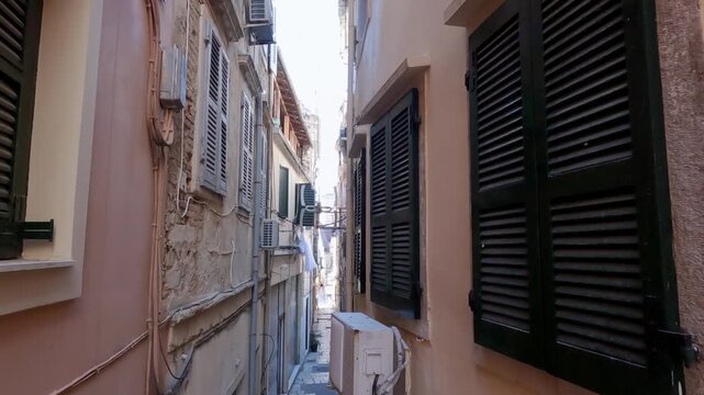 Drone moving by the narrow street alley of old city of Kerkyra Corfu island Greece, slow motion