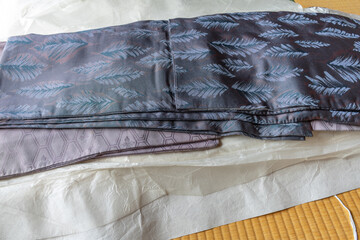 畳の上に複数枚の重ねた着物