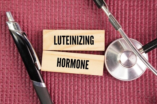 Stethoscope, pen and stick with the words Luteinizing hormone LH is a crucial pituitary gland hormone that regulates sexual development and reproduction in both sexes