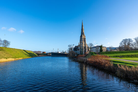 St. Alban&rsquo;s Church reflected along the moat in Copenhagen, Denmark, on a clear winter day.