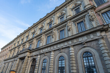 Obraz premium Ornate exterior facade of the Royal Palace in Stockholm, Sweden, highlighting baroque architectural elements, sculpted stone figures, arched windows, decorative columns, and historic European design u