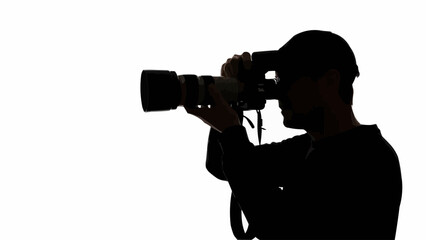 Silhouette of a photographer holding a professional camera and lens.