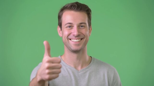Joyful young man gives a thumbs up, symbolizing approval, success, and positive affirmation with a beaming smile and a confident, optimistic outlook