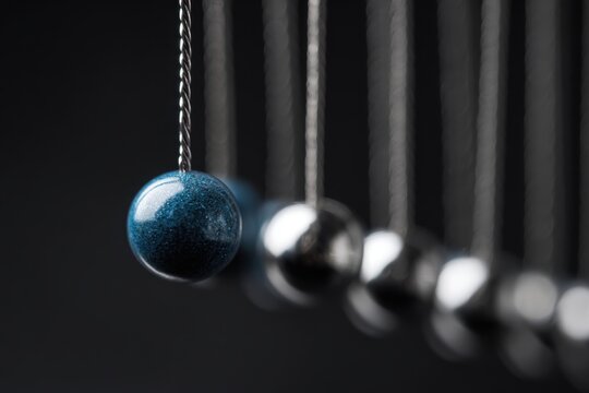 Close-up of a row of metallic pendulums
