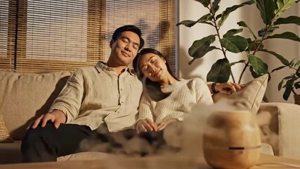 Asian Couple Relaxing At Home With Aromatherapy Diffuser Promoting Well Being
