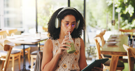 Woman, headphones and tablet in cafe with drink, audiobook or check online university portal....