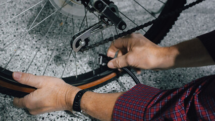 a person inflating a bicycle tire using a bike pump. active lifestyles and sports design element. bicycle maintenance.