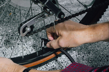 macro close-up of a person inflating a bicycle tire using a bike pump. active lifestyles and sports design element. bicycle maintenance.