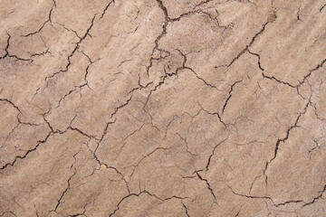 Soil texture. Dry, cracked silt ground, brown background, wallpaper.