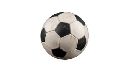 A worn soccer ball with a traditional black and white pattern against black background