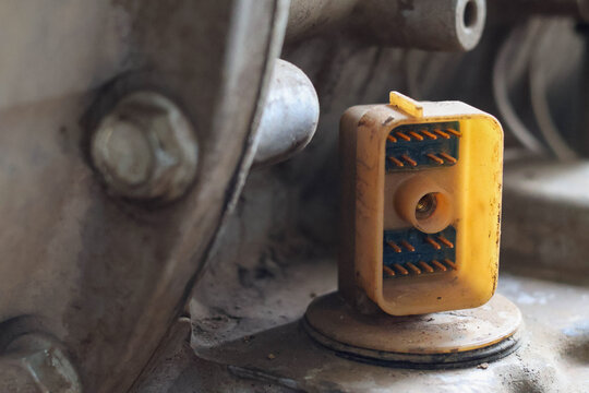 Close-up of a multi-pin electrical connector plug socket on an allison transmission showing copper pins and plastic casing.