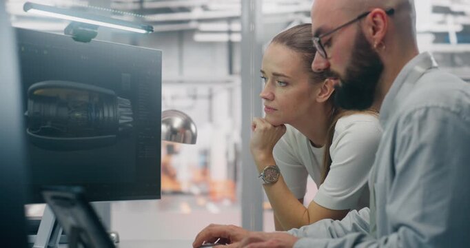 Specialists Discussing Manufacturing Specifications. Two Technical Specialists Deeply Engaged in Design Review, Examining Complex Technical Models on Computer Screen. Critical Problem Solving.