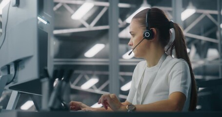 Specialist Manages Network Systems From Workstation in Network Operations Center. Woman Wearing Professional Headset Coordinate Tasks. Proactive System Monitoring and Coordinated Digital Operations.