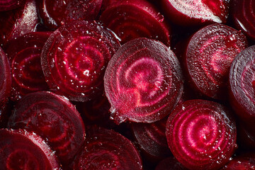 Close up overhead shot of fresh organic red beetroot slices showing natural textured rings and patterns.
