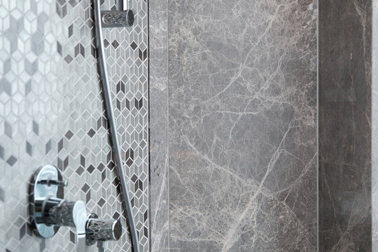 the wall next to the shower in the bathroom with beautiful barble texture wallpaper background