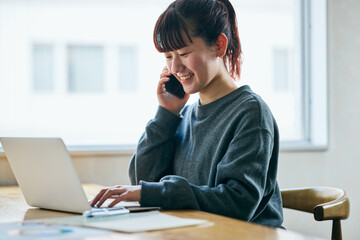 電話対応する在宅ワークの若い女性