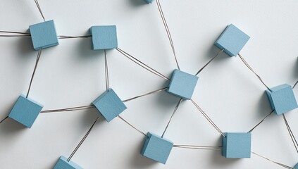Abstract network of light blue cubes connected by thin wires on a white surface
